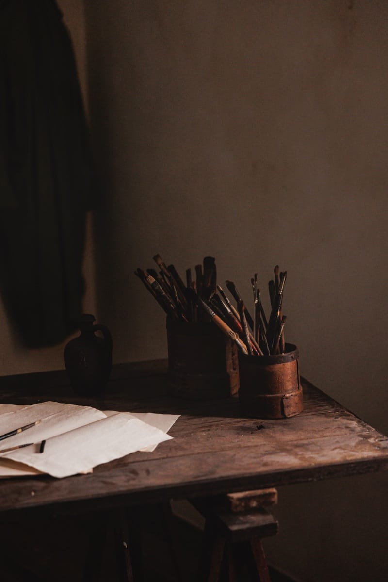 Painter's brushes and paper sheets on a wooden table in Vincent's first studio recreation
